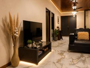 a living room with a television and a couch at Althi Mountain House in Naranjito
