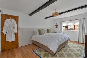 a bedroom with a bed and a robe hanging on a door at Finest Retreats - Poundtree in Wherwell