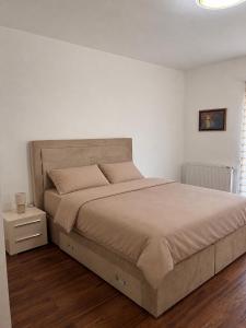 a bedroom with a large bed with a nightstand and a bed sidx sidx sidx at Apartman Rosić in Arilje