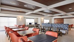 a dining room with tables and chairs and windows at Holiday Inn Express Hotel & Suites Milwaukee Airport by IHG in Greendale +76 photos
