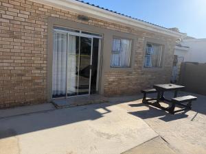 a picnic table and a bench in front of a building at The041Stay in Gqeberha