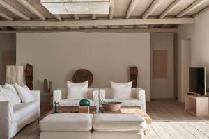 a living room with two white couches and a table at The Margi Villa Mykonos in Agios Sostis Mykonos