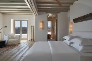 a white bedroom with a large bed and windows at The Margi Villa Mykonos in Agios Sostis Mykonos +27 photos