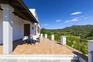 a balcony of a house with a table and chairs at Villa Rurale con Vista by Propertize in Monti