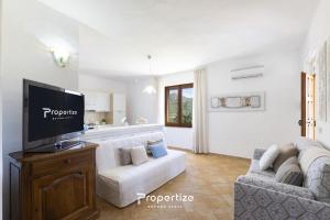 a living room with a white couch and a tv at Villa Rurale con Vista by Propertize in Monti