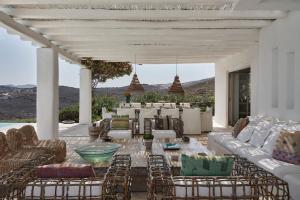 a patio with white furniture and a table and chairs at The Margi Villa Mykonos in Agios Sostis Mykonos
