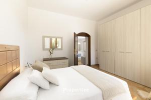 a white bedroom with a large bed and a mirror at Villa Rurale con Vista by Propertize in Monti
