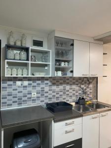 a kitchen with white cabinets and a sink at Kuca za odmor-Tisa Hideaway in Turija