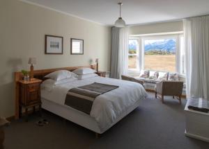a bedroom with a large bed and a large window at Estancia Cristina Lodge - El Calafate in Estancia Cristina