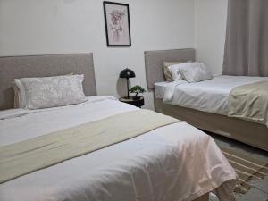 two beds sitting next to each other in a bedroom at The041Stay in Gqeberha +5 photos