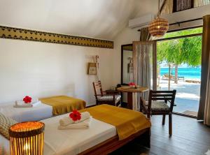 two beds in a room with a view of the ocean at Juana Ocean Villas in Makunduchi
