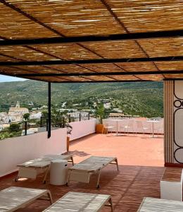 a patio with tables and chairs on a roof at Hotel Cadaqués1962 by Fimedhotels in Cadaqués