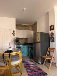 a kitchen with a stainless steel refrigerator and a table at Chalet in La mera north coast in Zāwiyat al ‘Awwāmah