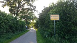 a sign on the side of a road with trees at "Schöne Auszeit" Ferienwohnung in Wiemersdorf