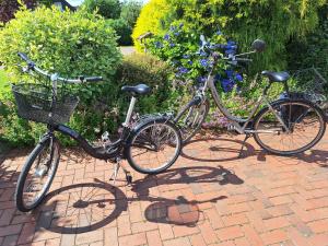 two bikes parked next to each other on a brick sidewalk at "Schöne Auszeit" Ferienwohnung in Wiemersdorf