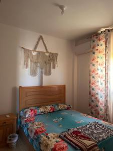 a bedroom with a bed and a window with curtains at Chalet in La mera north coast in Zāwiyat al ‘Awwāmah +3 photos