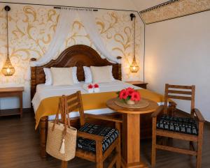 a bedroom with a bed with a table and chairs at Juana Ocean Villas in Makunduchi