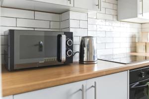 a microwave oven sitting on a counter in a kitchen at Saint Johns Rest in Biggleswade