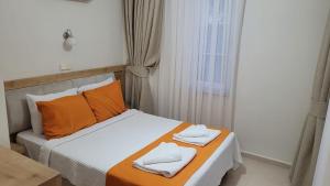 a bedroom with a bed with two towels on it at Tayfun Apart Hotel in Oludeniz +60 photos