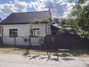 a white house with a wooden fence in front of it at Golden House in Khust
