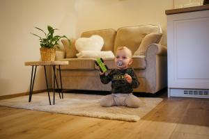 a baby sitting on the floor in a living room at Wellness Chata Trvalka in Píkovice +35 photos