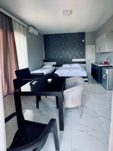 a room with two beds and a table and a kitchen at Grand Hotel Kobuleti in Kobuleti