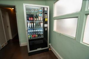 a soda machine in the corner of a room at Urban Garden Hostel in Lisbon