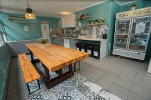 a kitchen with a wooden table and a counter at Urban Garden Hostel in Lisbon
