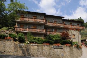 a building on top of a stone wall with flowers at Hotel Archimede in Reggello