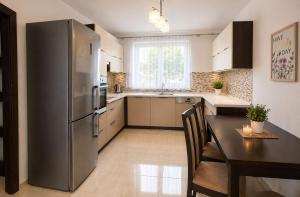 a kitchen with a stainless steel refrigerator and a table at Apartmán Hollého in Žilina