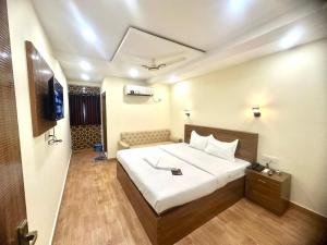 a hotel room with a bed and a television at Hotel Tu Casa in Kolkata