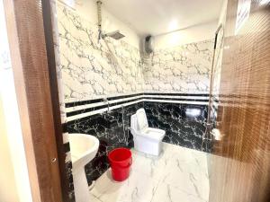a bathroom with a toilet and a sink at Hotel Tu Casa in Kolkata