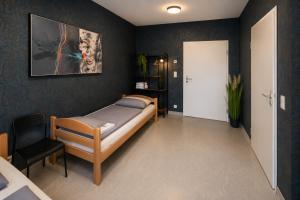 a bedroom with a bed and a chair in it at Moderne Appartement in Nuremberg +8 photos