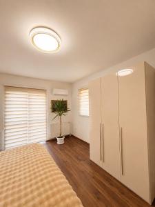 a bedroom with a bed and a cabinet and a plant at Apartman Rosić in Arilje