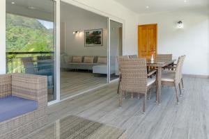 a dining room with a table and chairs and a couch at Voilà Beau Vallon in Beau Vallon