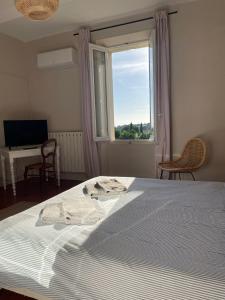 a bedroom with a large bed with a window at Mas Bérenger in Beaumes-de-Venise +13 photos