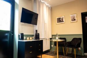 a room with a tv and a table and chairs at La Suite Fernand Bar in Béthune +5 photos