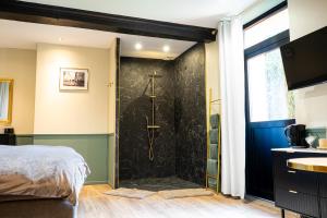 a bedroom with a shower with a black wall at La Suite Fernand Bar in Béthune