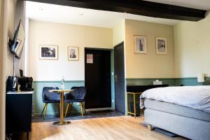 a bedroom with a bed and a table and chairs at La Suite Fernand Bar in Béthune
