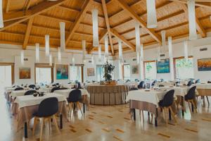 a banquet hall with white tables and chairs and wooden ceilings at Hotel Crystal in Preganziol