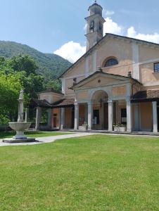 a large building with a clock tower and a fountain at Appartamento Casa Libe in Ornavasso