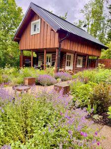 a house with a garden with flowers in front of it at Wellness Chata Trvalka in Píkovice