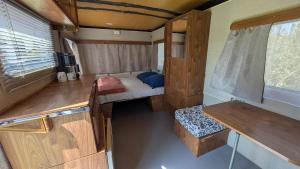 an interior view of an rv with a bed and bench at Caravane Cosy - 5min Circuit 24h du Mans in Changé