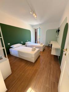 a bedroom with two beds and a green wall at Almaré Luxury Beach Apartments in Taranto +139 photos