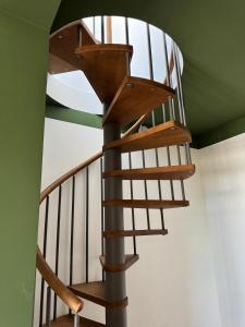 a wooden spiral staircase in a green ceiling at Almaré Luxury Beach Apartments in Taranto