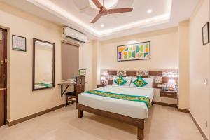 a bedroom with a bed and a desk and a mirror at Treebo Golden Sun Inn, 5 Mins To Rock Beach in Pondicherry +34 photos