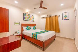 a bedroom with a bed and a dresser in it at Treebo Golden Sun Inn, 5 Mins To Rock Beach in Pondicherry