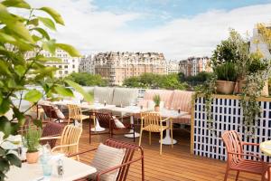 a patio with tables and chairs on a balcony at Molitor Hotel & Spa Paris - MGallery Collection in Paris