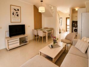 a living room with a couch and a tv at Guest House Forest 20 in Balchik