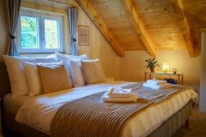 a bedroom with a bed with two towels on it at Wellness Chata Trvalka in Píkovice